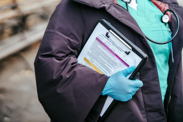 A healthcare professional in scrubs holds a wound care competency checklist, emphasizing the importance of Accurate Data Entry.