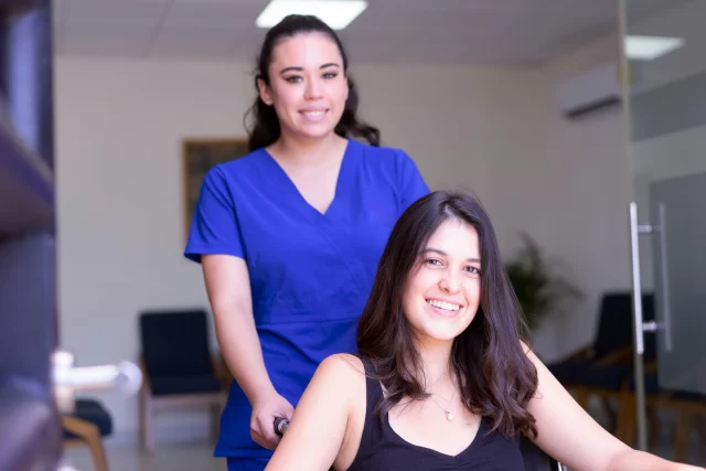 A medical professional assisting a patient in a clinic, representing professional Care Coordination.