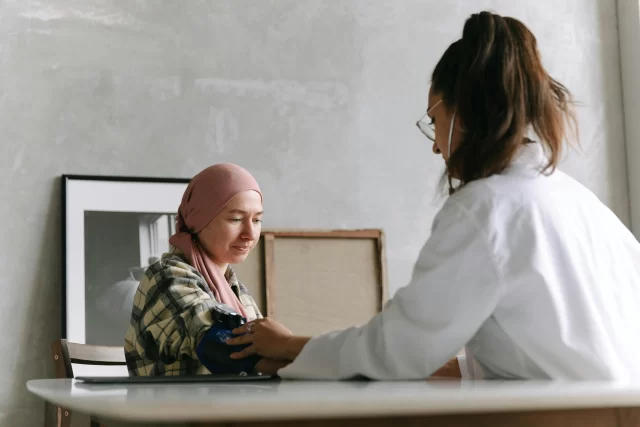 A healthcare professional checks a patient's blood pressure during a routine Care Coordination visit.