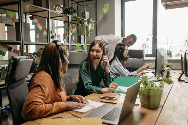Office team collaborating on workstations to streamline Business Function Outsourcing.