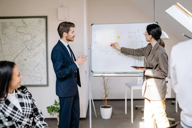 Professionals collaborating on a presentation during a Business Function Outsourcing strategy session.