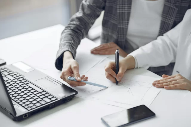 Two professionals collaborating on a chart during a Health Info Management planning session.