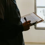 A warehouse worker reviewing inventory documentation, highlighting the role of Managers for pharmacy benefit.