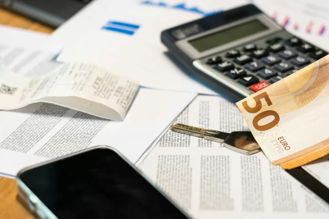 Calculator, cash, and documents on a desk representing regulatory compliance updates EU.