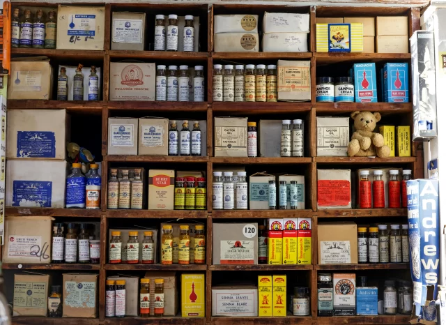 Vintage apothecary shelves filled with various medicinal bottles, illustrating the inventory oversight that can cause revenue leakage in pharmacies.