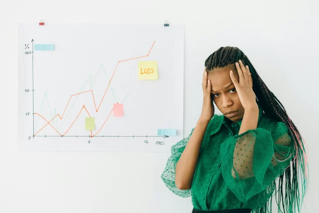 A frustrated professional standing before a chart showing market fluctuations, highlighting the need for a reliable Swiss PIM.
