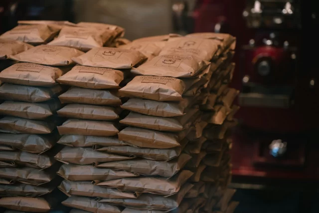 Stacks of Kurukahveci Mehmet Efendi coffee bags, representing efficiency in operations like healthcare operations cost reduction.