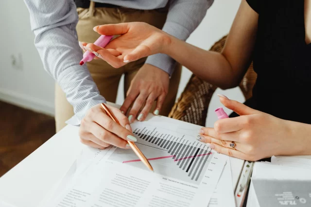 Benefit Managers analyzing European data trends on a printed bar chart during a business consultation